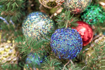 Blue Christmas ball with sparkles and bugles on the Christmas tree.
