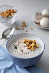 mushroom soup whis croutons in a blue cup on a white background