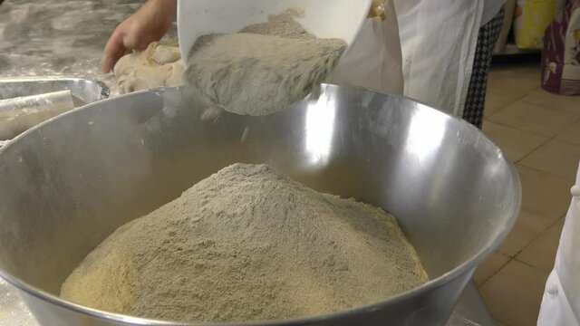 Laboratorio di una panetteria con fornaio che prepara il pane in maniera artigianale