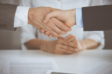 Obraz premium Business people shaking hands finishing contract signing, close-up. Business communication concept. Handshake and marketing