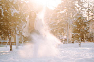 Young beautiful woman  posing in a snowy park. Cold weather. Winter fashion, holidays, rest, travel concept.