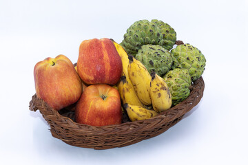 Fresh Apples, Bananas and custard apples kept on a wooden basket
