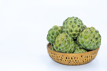 Fresh green Custard apples kept on a wooden basket with white background
