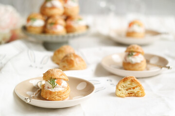 A traditional French cheese puffs or Gougères in a plate filled with fresh cheese mixed with smoke salmon, dill leaf. A pastry base of savory choux dough with a generous amount of cheese folded in. 