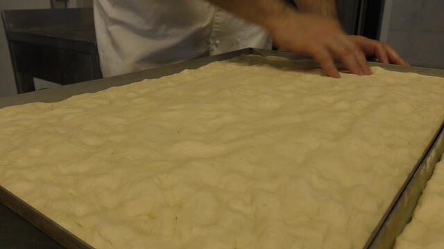 Laboratorio di una panetteria con fornaio che prepara il pane in maniera artigianale