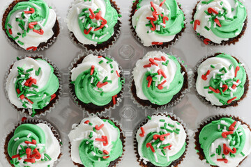 plastic tray of mini christmas cupcakes with sprinkles