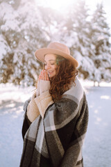 Fototapeta premium Young woman enjoying winter weather in the snow forest. Cold weather. Winter fashion, holidays, rest, travel concept.