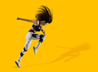 Fototapeta na wymiar Sporty woman running on isolated on yellow background