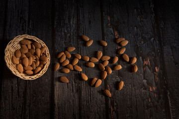almond in basket on dark wooden table