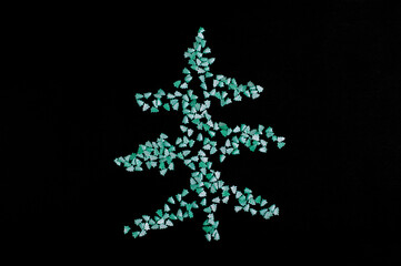 Christmas tree made of green sugar sprinkles on the black table. Top view. Festive background