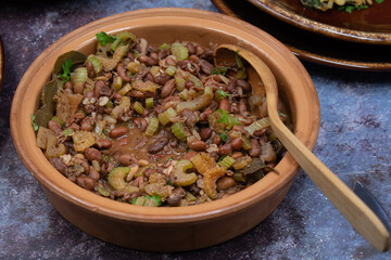 Mexican bean and celery stew in clay dish