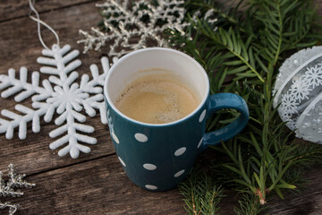 Obraz na płótnie Canvas blue polka dor mug with fresh coffee and winter decoration on wooden ground 