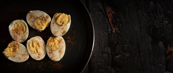 boiled eggs with spice on dark wooden table
