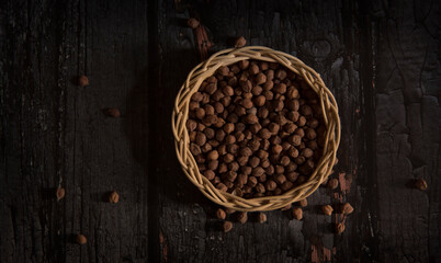 Black Chickpeas in basket on dark wooden background.