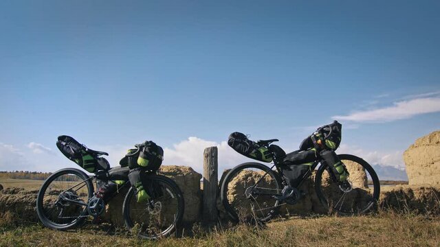 The mixed terrain cycle touring bike with bikepacking. The travel journey with light bicycle bags designed or modified for cycling. The trip on multitrack bike, outdoor road in mountain snow capped.