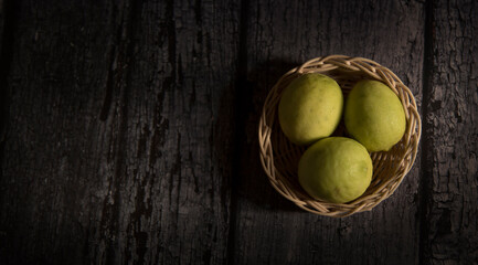 lemons in the basket with dark wooden background