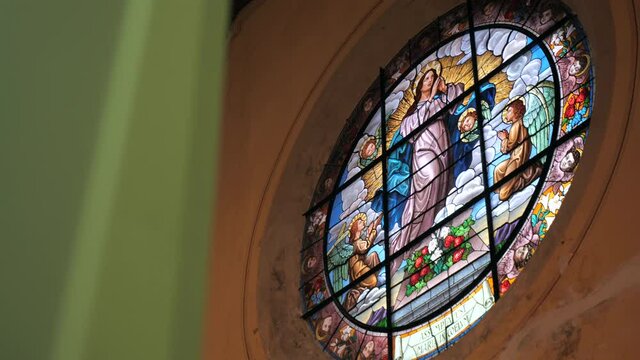 slider shot of virgin Mary and angels glass vitrage window in old cathedral