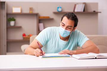 Young male student studying at home during pandemic