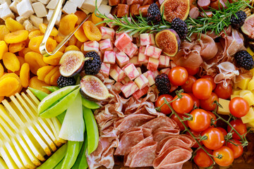 Close up of charcuterie board with cheese, fig, and crackers.