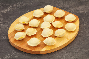 Raw dumplings over board for cooking