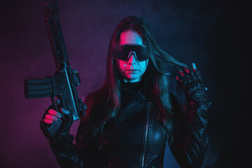 Futuristic girl soldier with a gun in the smoke on the dark background.