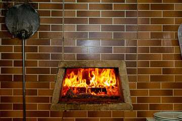 Refractory brick pizza oven to withstand high temperatures with firewood burning and being prepared...