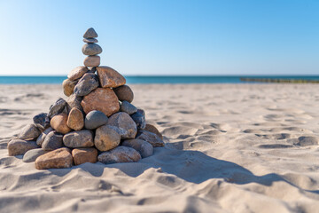 Pyramide aus Steinen am Strand vor dem Hintergrund von Meereswellen und  Sandstand auf dem Darß...