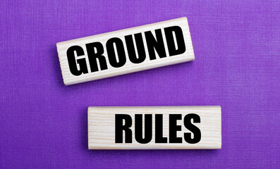 On a lilac bright background, light wooden blocks with the text GROUND RULES