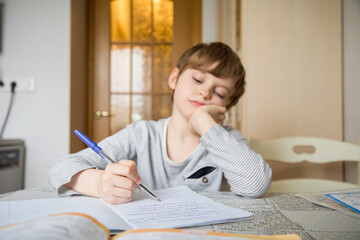 A first-grader boy does his homework in isolation.