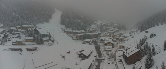 Aerial drone panorama of Santa Caterina di Valfurva village during a heavy snow storm in winter....