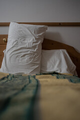 Fototapeta na wymiar Two white pillows in a hotel resting on a bed ready to support tired back of a person resting.