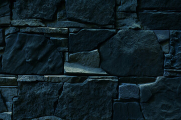 Dark wall made of natural stone. Close-up