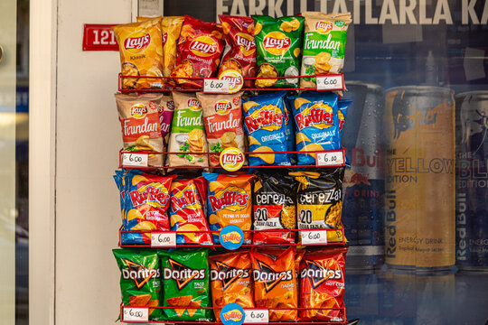 Packaged FMCG (Fast moving consumer goods) products including potato chips and corn chips displayed on a street shelf of a kiosk. Besiktas, Turkey - Nov 17 2020.