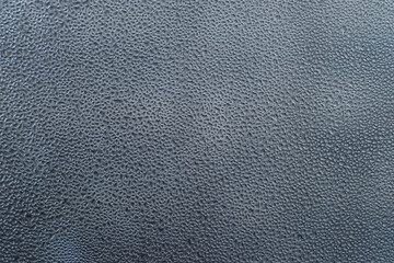 Small drops of condensate water on window glass, horizontal, closeup