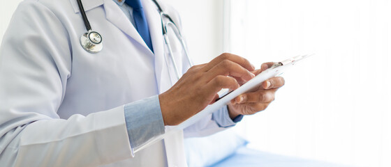 banner picture of doctor in white coat looking at document of patient in hospital