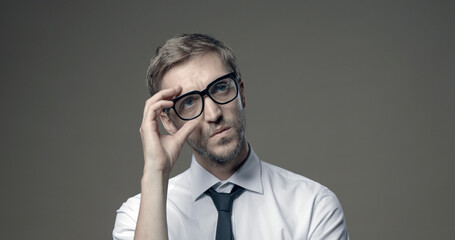 Confident businessman adjusting his glasses