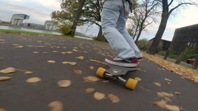 man skateboarding alone in German park, close up in foot