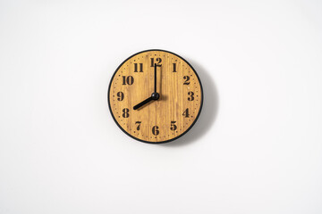 wood office wall clock with white dial on white background. wall clock on white background, top view.