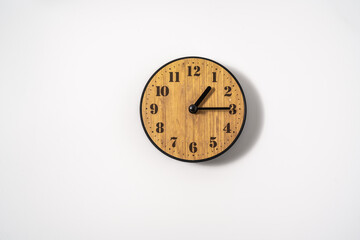 wood office wall clock with white dial on white background. wall clock on white background, top view.