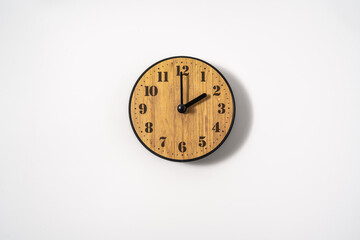 wood office wall clock with white dial on white background. wall clock on white background, top view.