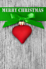 Red heart and Merry Christmas against wooden background