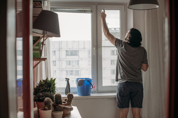 A man washes windows at home