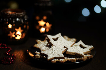 ginger cookies in icing sugar on a plate on a dark background