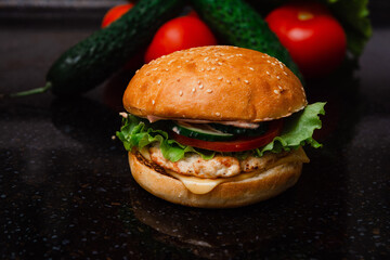 Homemade cheeseburger made from turkey. The ingredients used were poultry breast, cucumber, tomato, lettuce, cheese and sauce.
