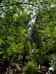 Fototapeta premium SQUAMISH, BC, CANADA, JUNE 02, 2019: People resting and sitting on stones at the foot of Shannon Falls, Squamish, British Columbia
