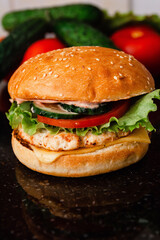 Homemade cheeseburger made from turkey. The ingredients used were poultry breast, cucumber, tomato, lettuce, cheese and sauce.
