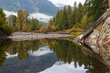 Mountain reflection in Little Wenatchee River during the autumn season.