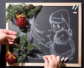 Drawing a snowman with crayons on a blackboard. Simple winter story