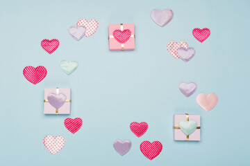 Pink textile hearts with polka dots and gifts on blue background. Valentines day concept. Flat lay, top view, copy space.