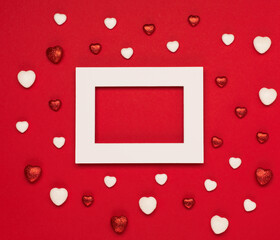 Red white hearts and empty frame on red background. Valentines day concept. Flat lay, top view, copy space.
